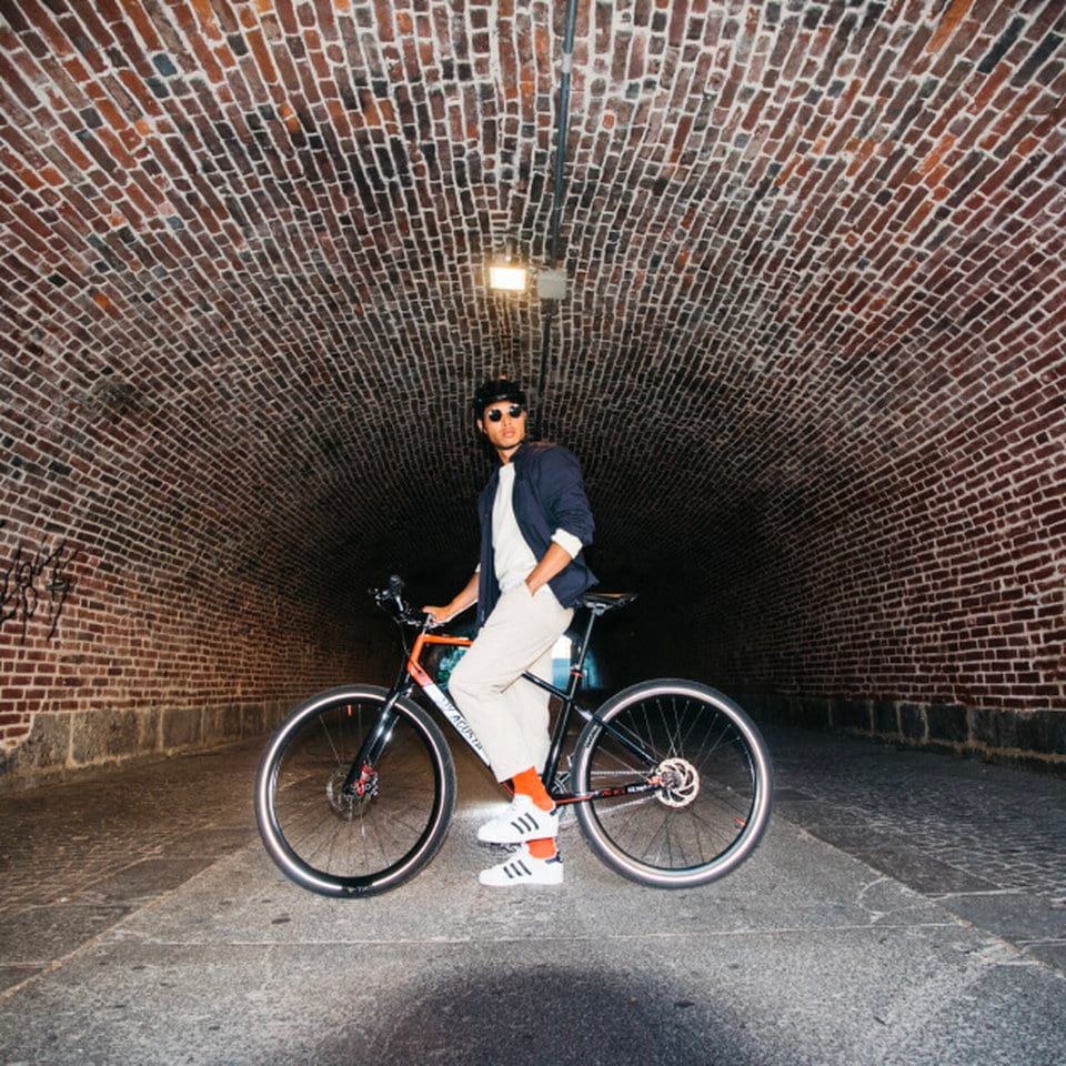 Rider on an MV Agusta AMO e-bike beneath a brick arch
